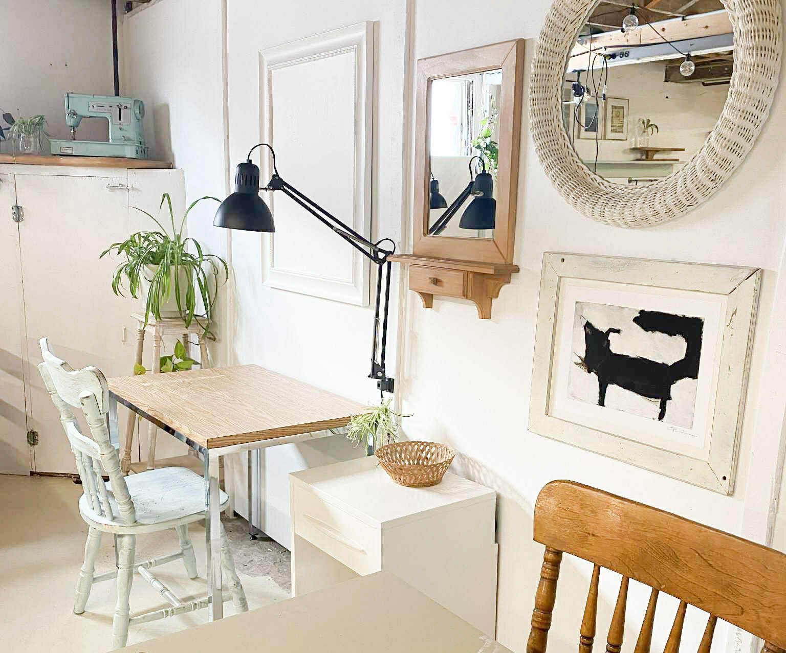 Photographie qui représente l'atelier couture de l'atelier collectif. Elle montre un espace de travail lumineux, des chaises, des tables de travail, des cadres et une plante.